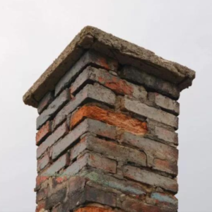 The top part of a masonry chimney in need of new bricks and mortar