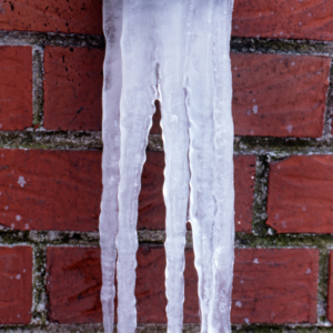 icicles hanging down by a masonry wall