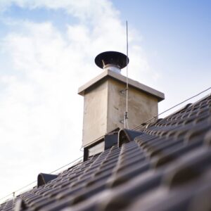 a chimney with a metal chase cover and chimney cap