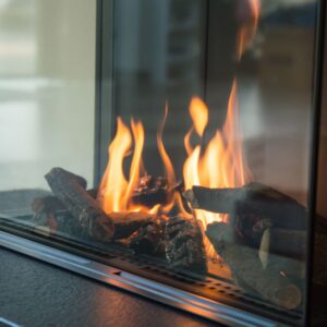 a gas fireplace with glass on three sides that's lit