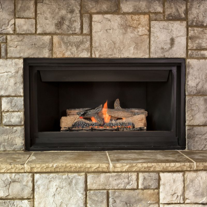 a gas fireplace with a stone facing - the stones are large and square and rectangular